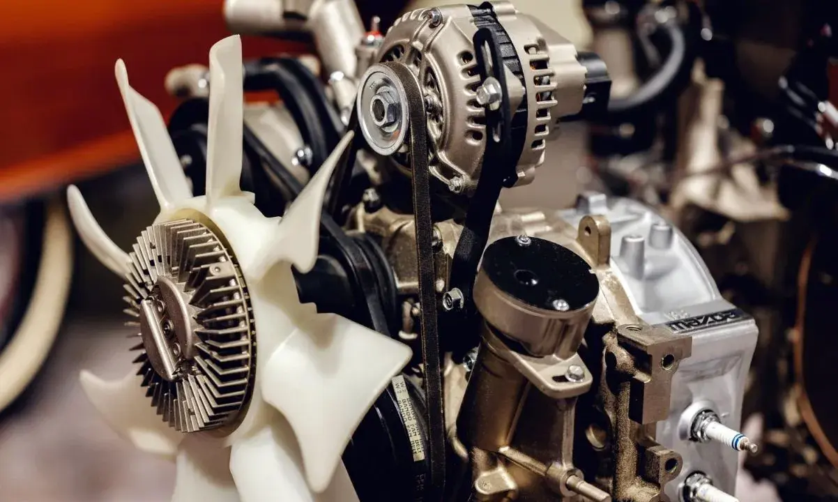 Motor de coche con ventilador y alternador. Imagina el **ruido ventilador coche apagado** antes de arrancar.