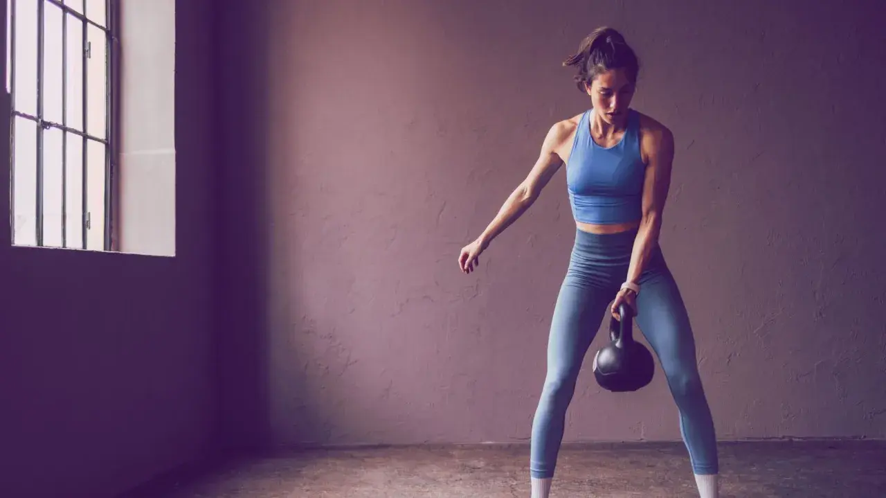 Frau trainiert mit Kettlebell, bereit für die 75 Hard Challenge.