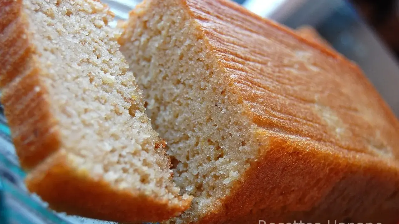 Un délicieux gâteau banane sans sucre, moelleux et doré, coupé en deux pour révéler sa mie aérée. Parfait pour un goûter sain.