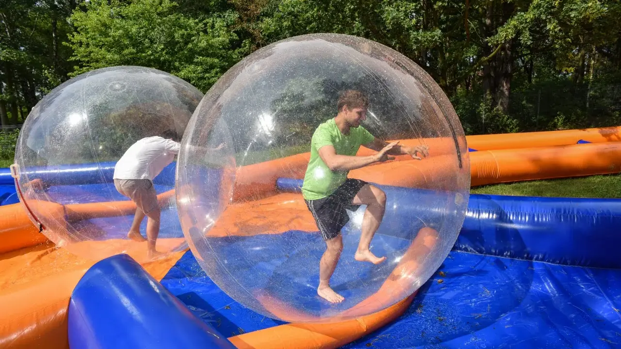 Świetne pomysły na team building: ludzie w dmuchanych kulach na wodzie, śmiech i zabawa gwarantowane!