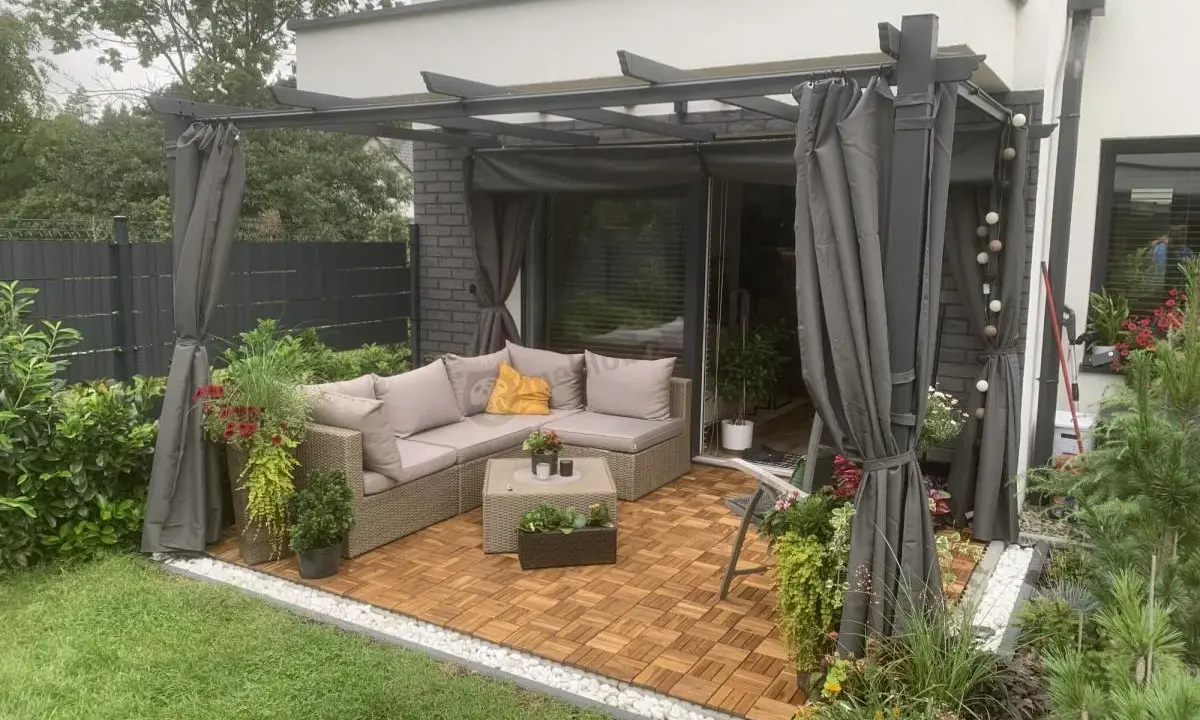 Nowoczesna pergola w ogrodzie z wygodnym narożnikiem i stolikiem. Idealne miejsce na relaks i inspiracje.