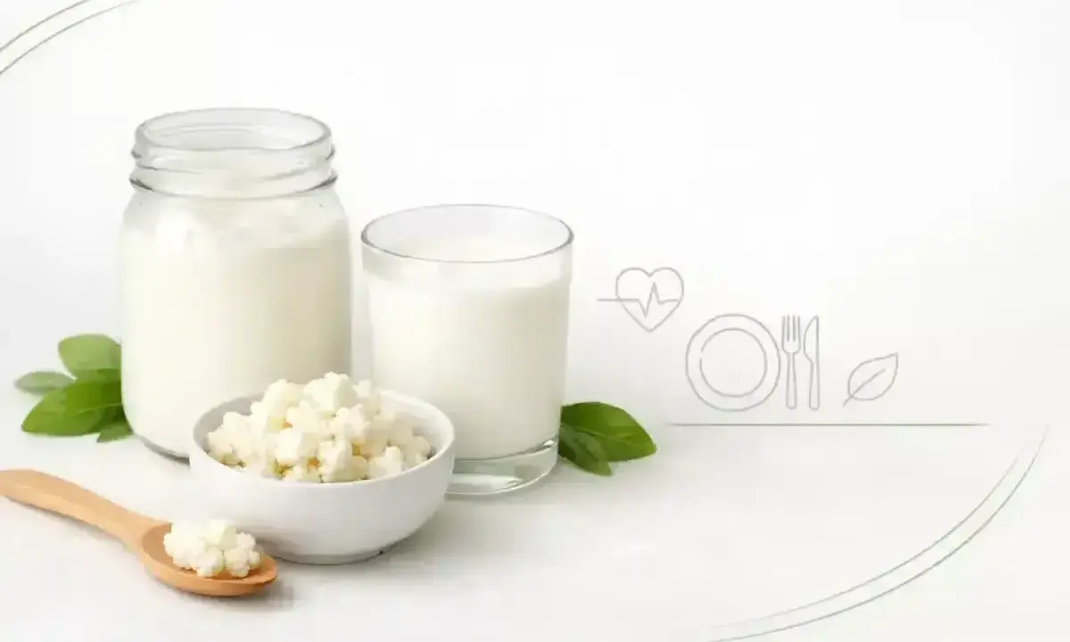 Kefir w słoiku i szklance, ziarna kefirowe na łyżce i w miseczce. Czy kefir jest zdrowy? Tak, to napój pełen probiotyków.
