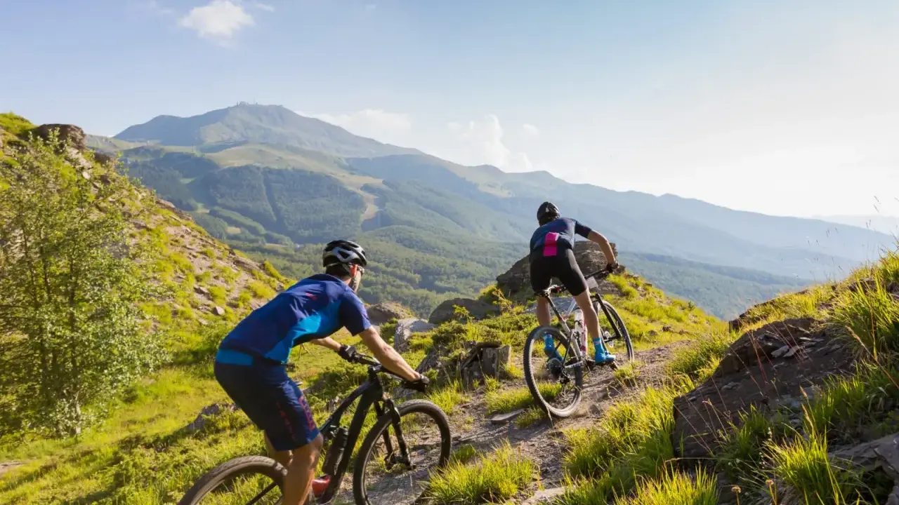Due ciclisti affrontano un sentiero montano, godendosi un'avventura in bici sulla Via degli Dei.