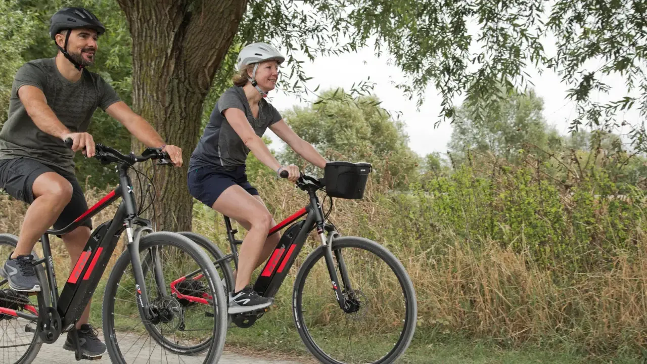 Para, jadąca na rowerze hybrydowym, co to znaczy? To połączenie wygody i wszechstronności, idealne na wycieczki po ścieżkach i drogach.