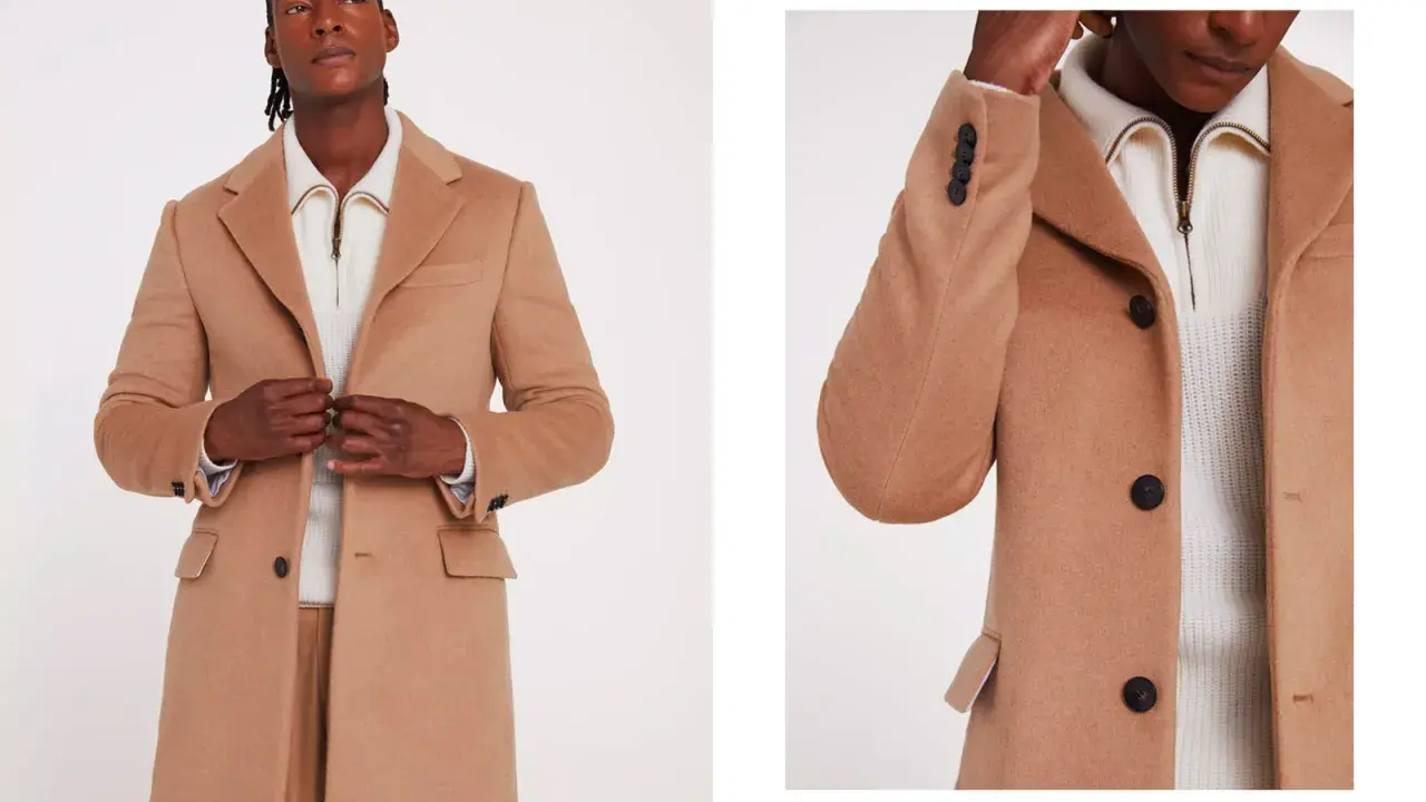 A man models a stylish camel coat, perfect for wearing with a suit. The coat features dark buttons and a classic lapel.