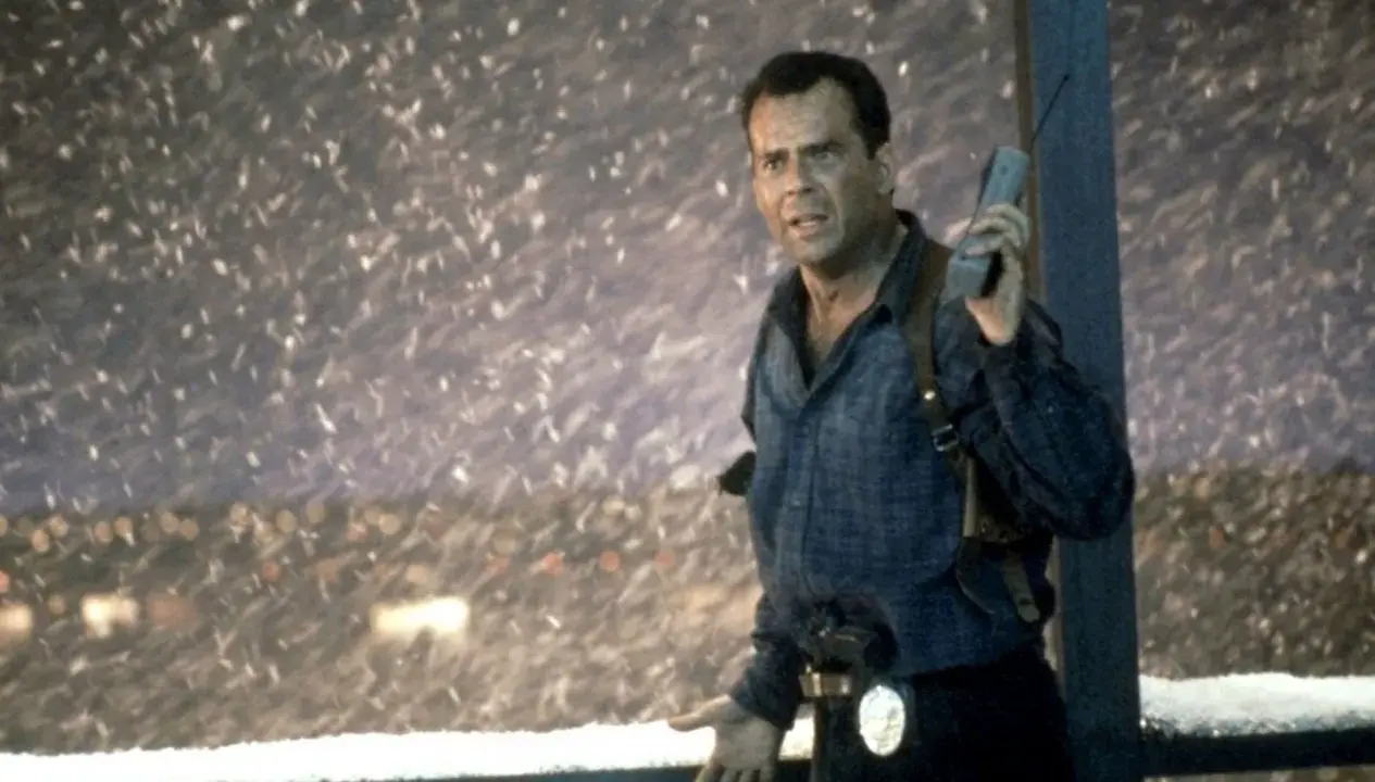 Bruce Willis som John McClane, mitt i snöstormen, med en gammal mobiltelefon i handen. En ikonisk scen från rollistan i Die Hard 2.