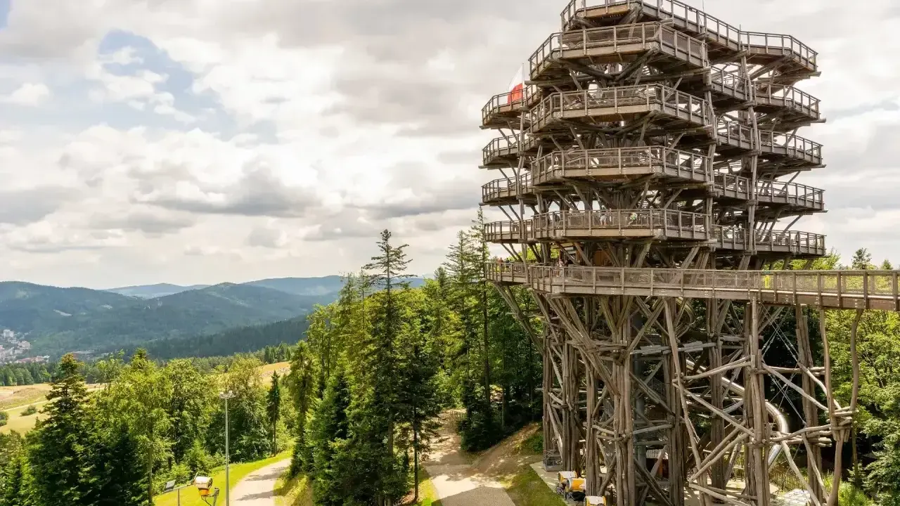 Wieża widokowa w Krynicy Zdroju, otoczona zielonymi górami, zaprasza do podziwiania panoramy Beskidu Sądeckiego.