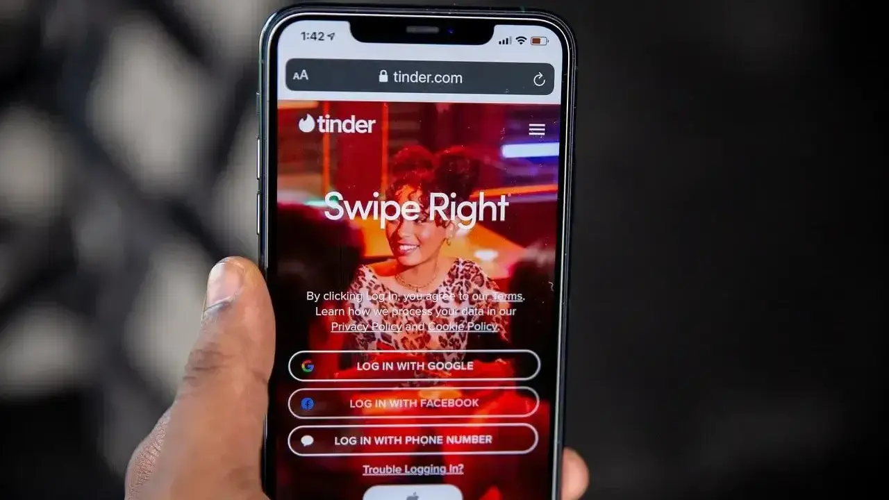 Ekran logowania Tindera z opcjami "Swipe Right", "Log in with Google", "Log in with Facebook" i "Log in with phone number". Szybkie skróty na Tinderze ułatwiają rozpoczęcie randkowania.