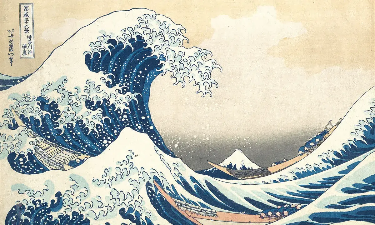 A massive blue wave crests, threatening boats below. In the distance, Mount Fuji, a peak from the "Thirty-six Views of Mount Fuji" series, stands serene.