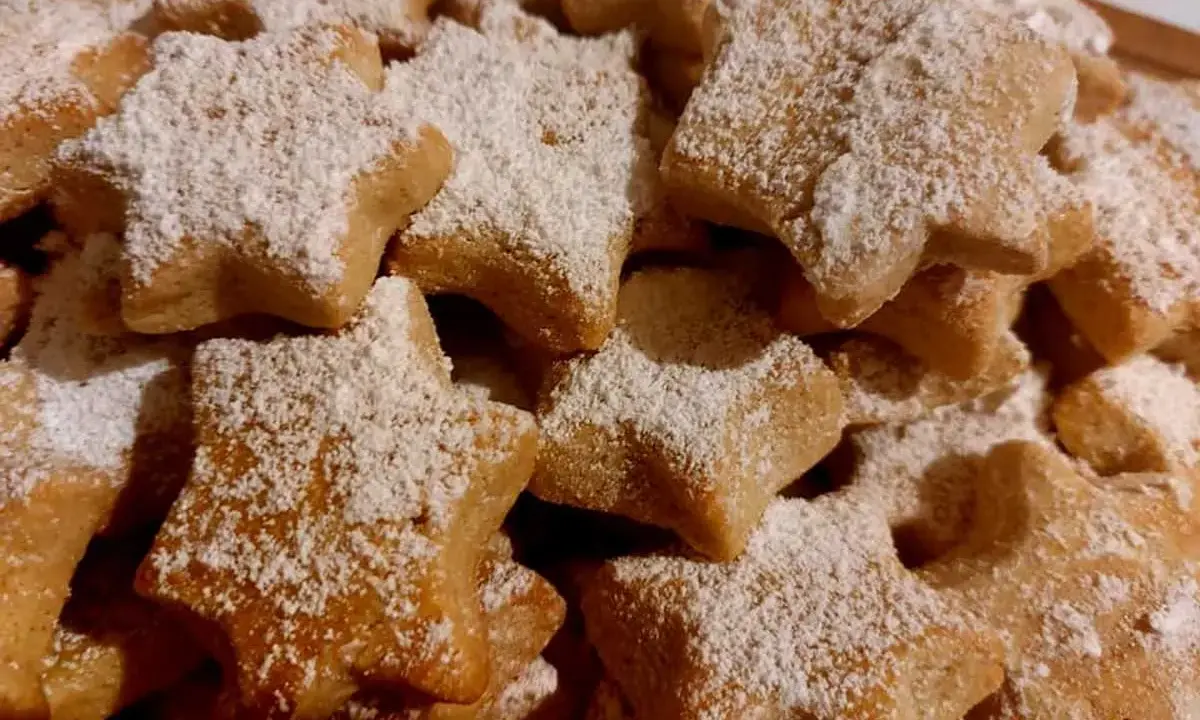 Deliciosas galletas caseras de pueblo con forma de estrella, espolvoreadas con azúcar glas. Perfectas para acompañar un café.