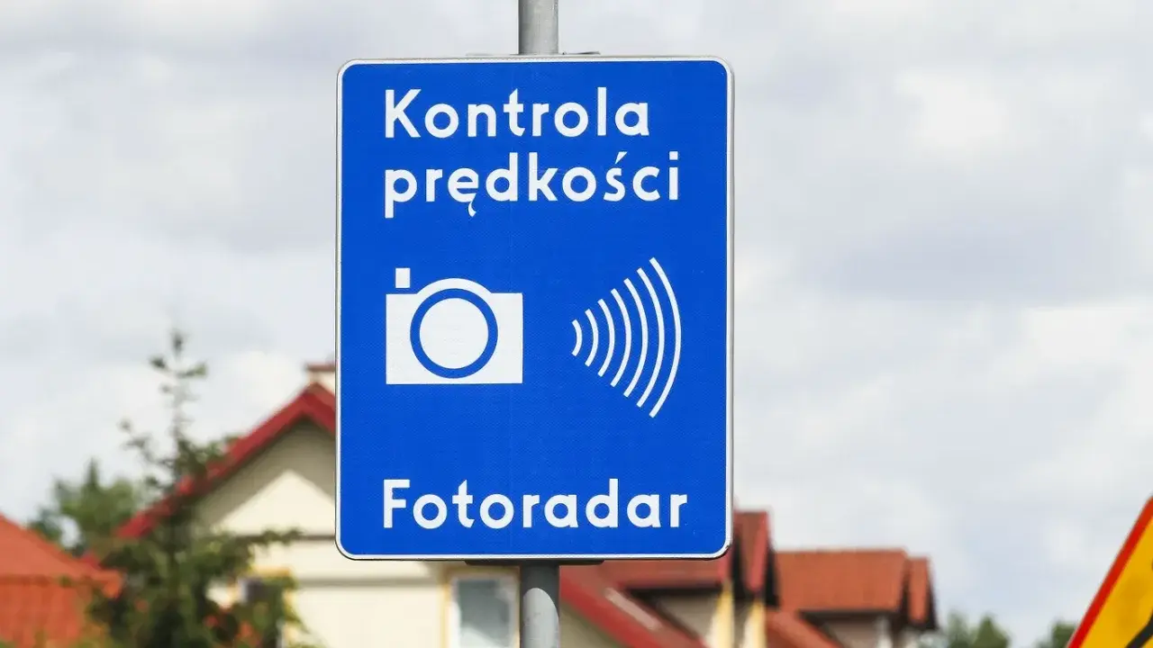 Niebieski znak informuje o kontroli prędkości. Fotoradar łapie kierowców przekraczających dozwoloną prędkość.