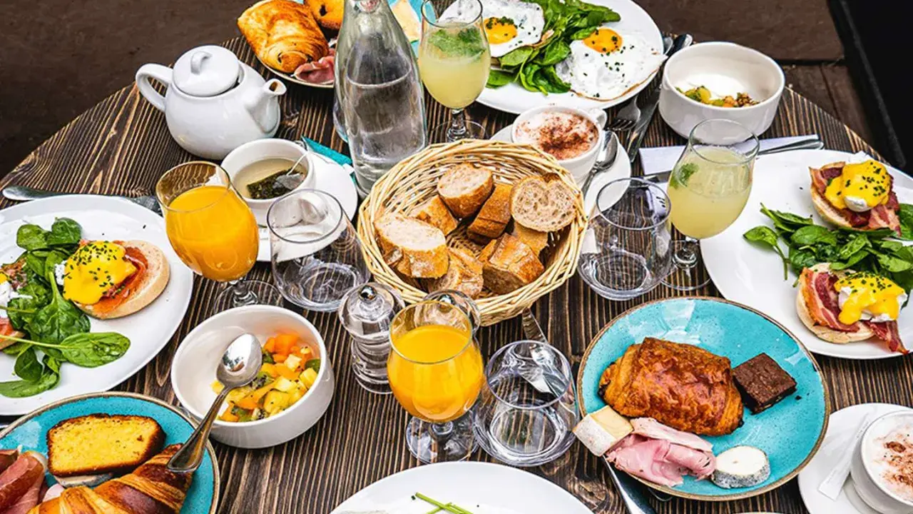 Un festin parisien : œufs Bénédicte, croissants, jus d'orange et café. Une spécialité parisienne pour un brunch gourmand.