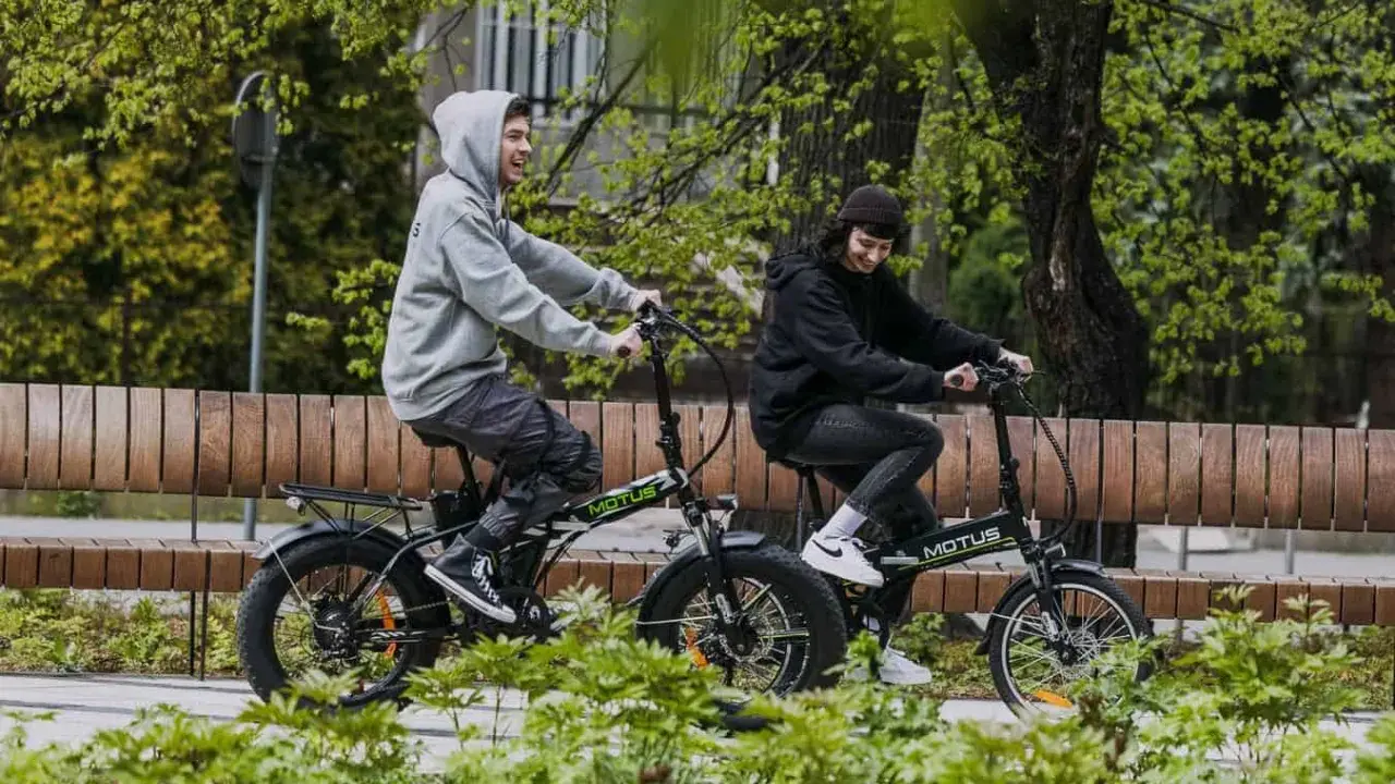 Dwie osoby cieszą się jazdą na rowerach elektrycznych. Dofinansowanie do roweru elektrycznego sprawia, że takie wycieczki są dostępne dla każdego.