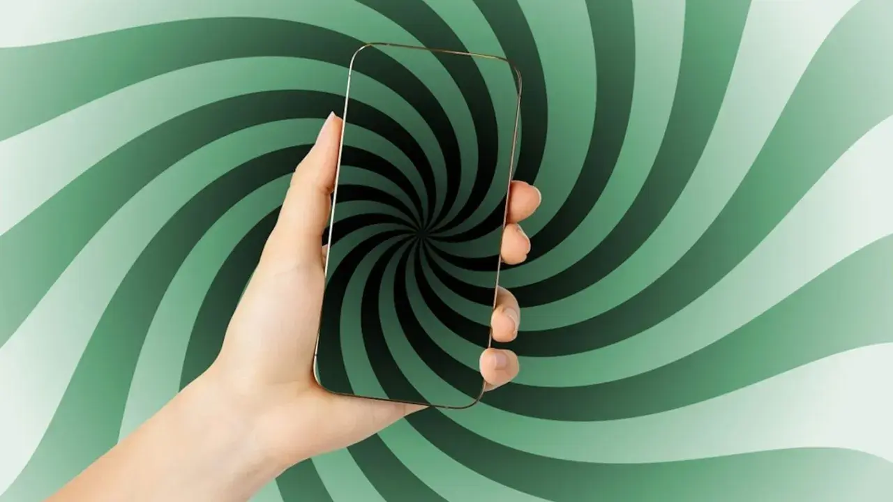Main d'une personne tenant un smartphone avec un fond tourbillonnant vert et noir. Le téléphone affiche un motif de spirale hypnotique, comme un scroller def.