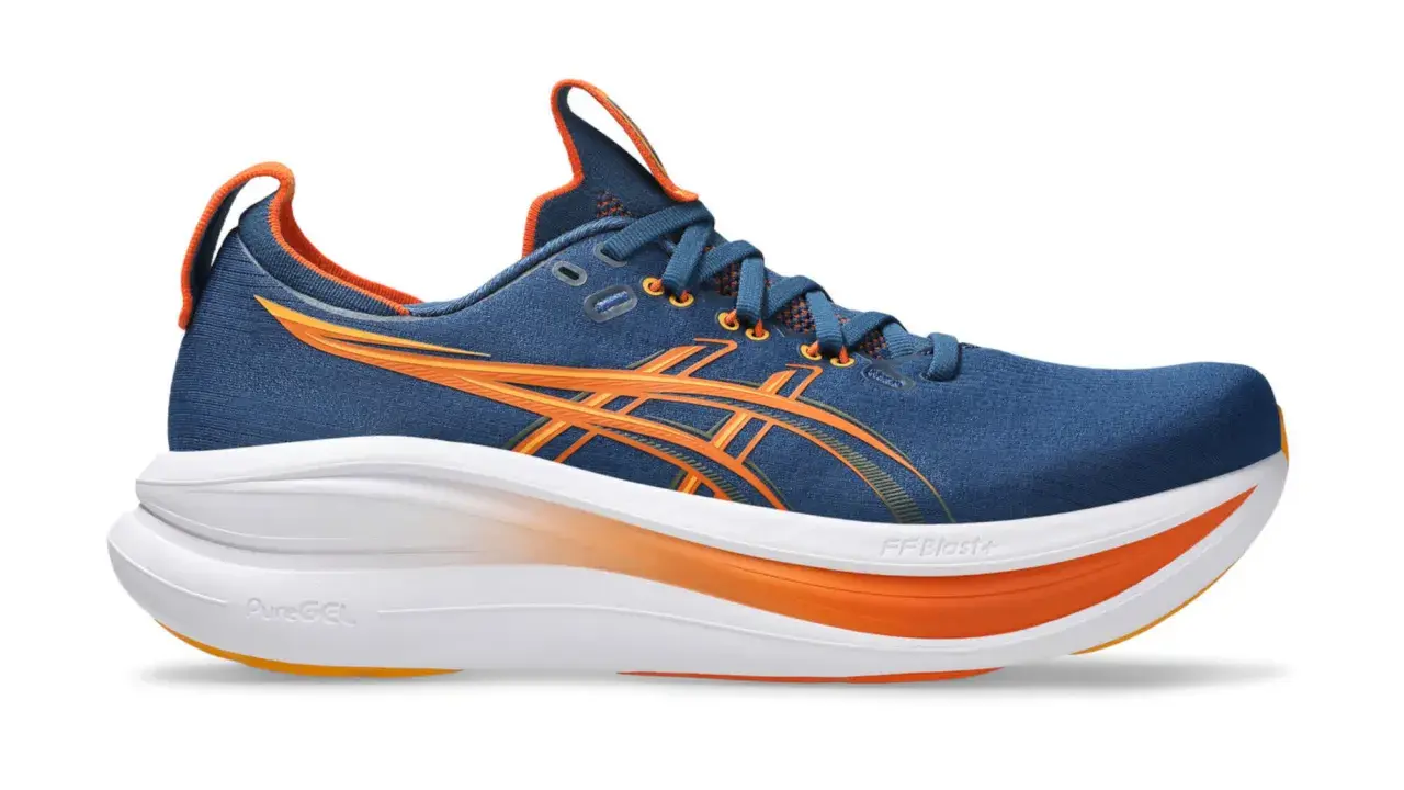 Granatowe buty do biegania z pomarańczowymi akcentami, idealne na maraton. Lekkie i amortyzujące, zapewnią komfort na długich dystansach.