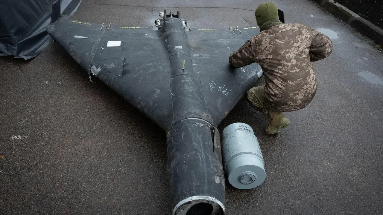 Ein Soldat inspiziert eine Drohne in Rumänien. Daneben liegt eine Munitionshülse.