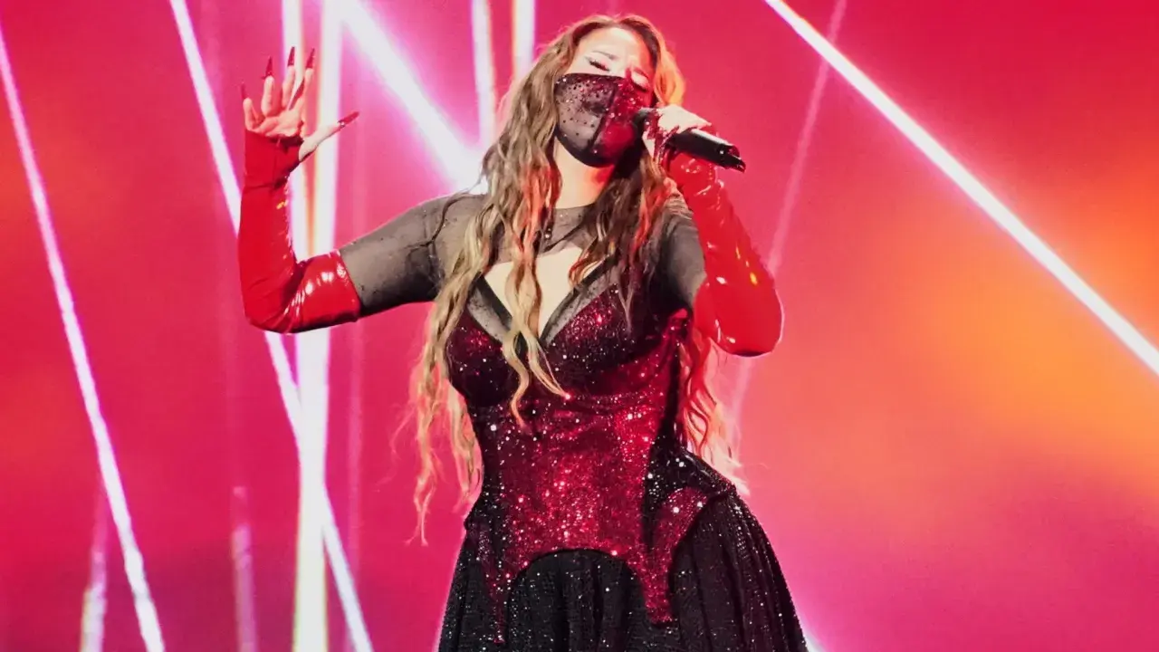 Artist med mask och röda handskar sjunger på scen. Kanske en försmak av Eurovision 2026 tid?