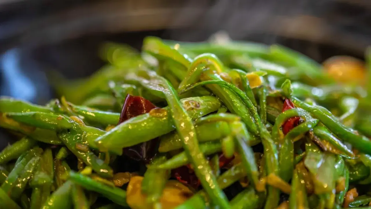 Haricots verts sautés avec des piments rouges, un plat simple et savoureux, parfait pour une recette haricot vert rapide.