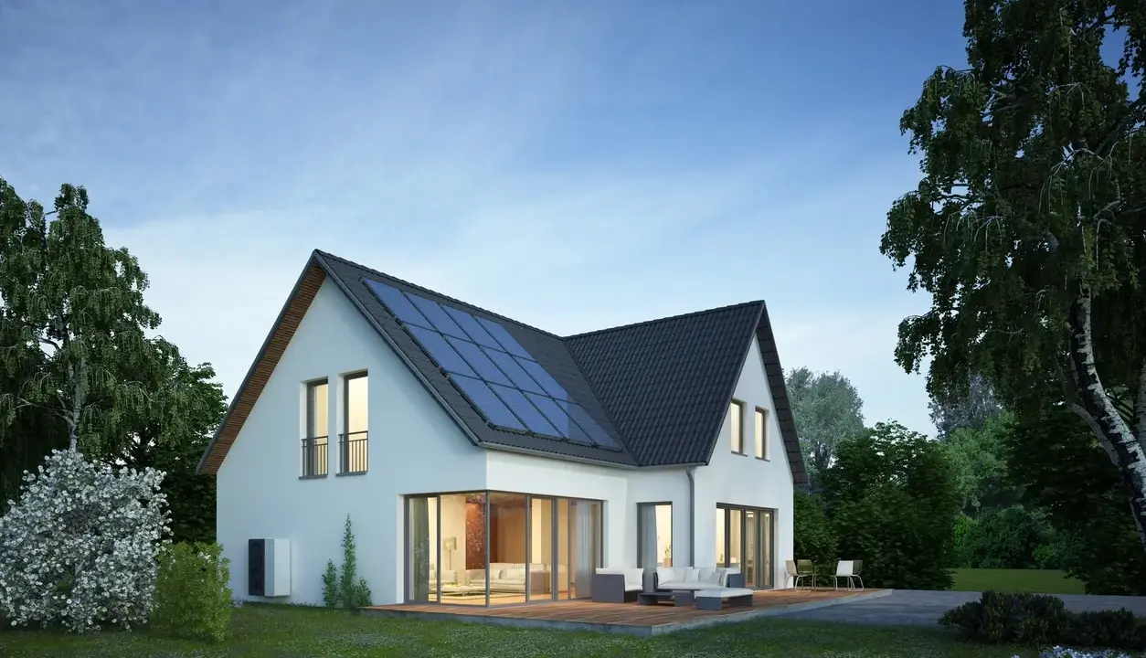 Modernes Haus mit Solaranlage auf dem Dach. Die Dachsanierung mit PV-Pflicht ist eine zukunftsorientierte Entscheidung für nachhaltige Energie.