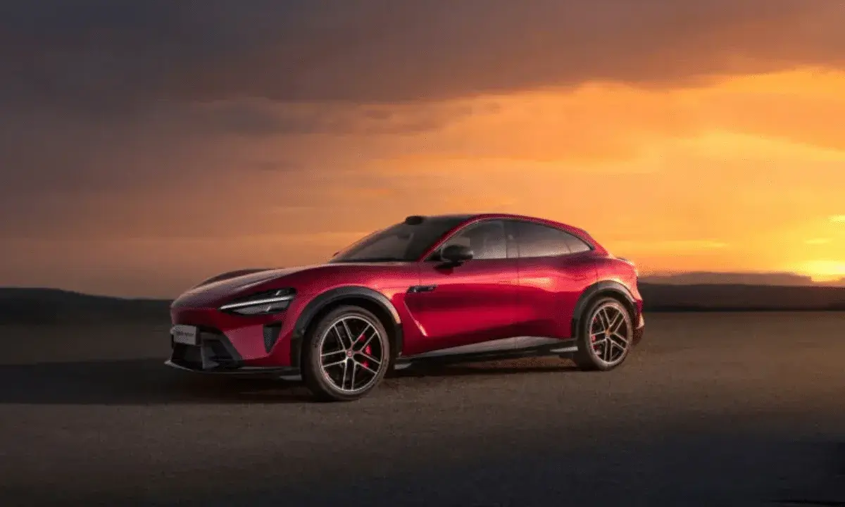 Le SUV rouge Xiaomi Yu7, aux lignes futuristes, se dresse sur un tarmac sous un ciel orangé spectaculaire.