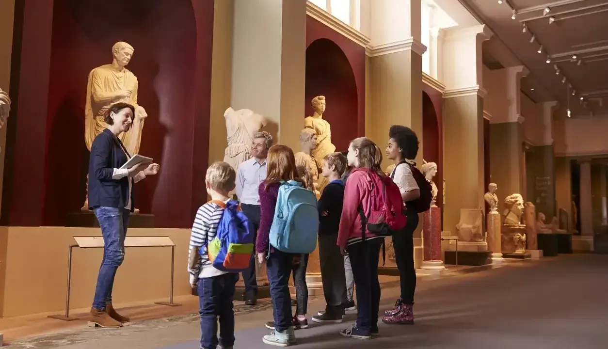 Un grupo de niños disfruta de las exposiciones en un museo de Madrid, aprendiendo sobre arte e historia con su guía.