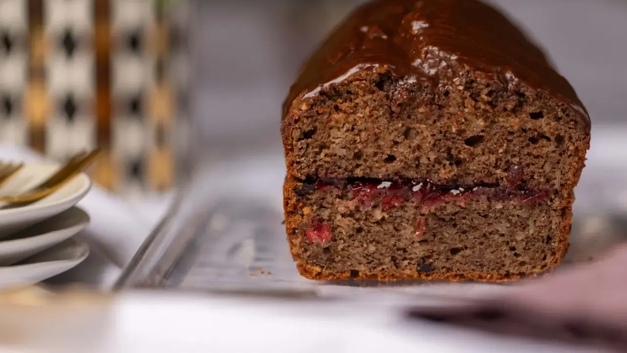 Saftiger buchweizen kuchen mit Schokoladenglasur und einer Füllung aus roter Marmelade.