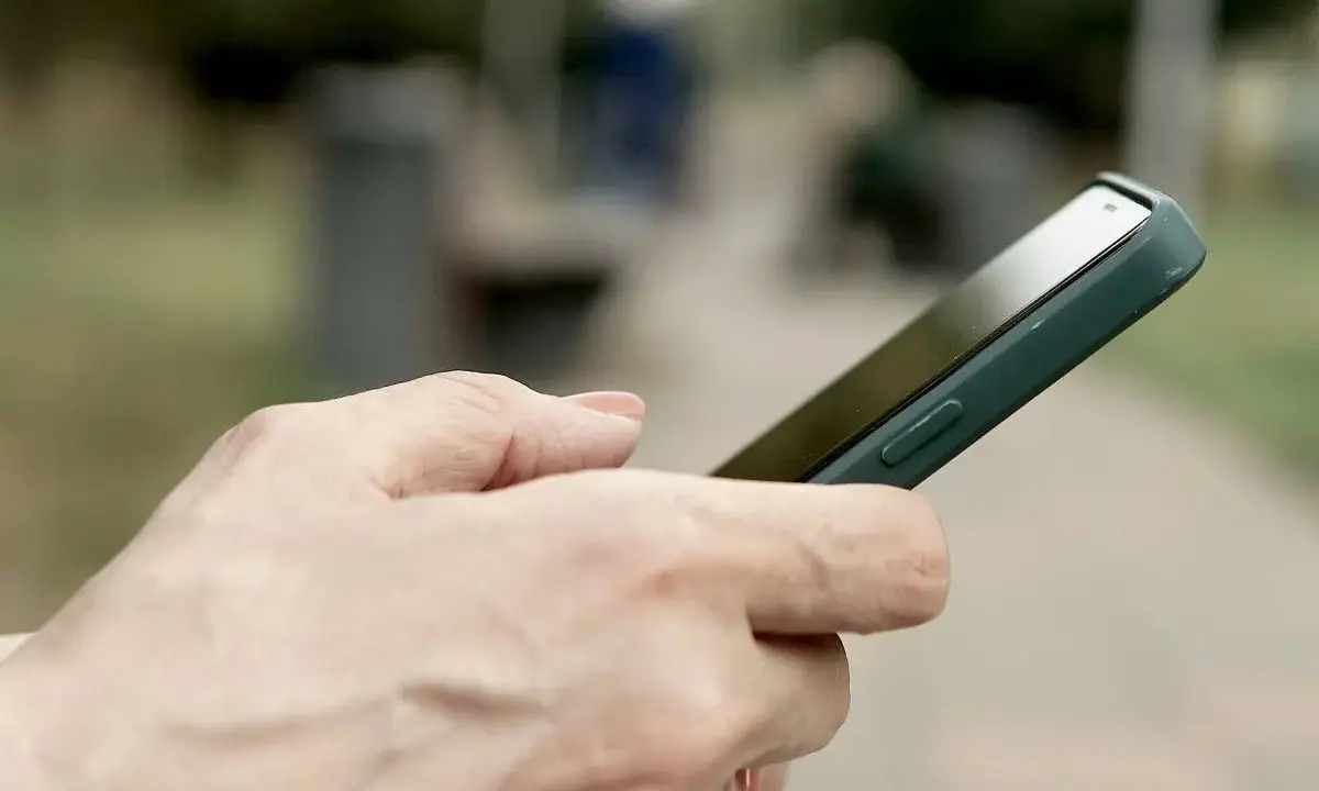 Dłoń trzyma smartfon Huawei, być może przygotowując się do wykonania hard reset.