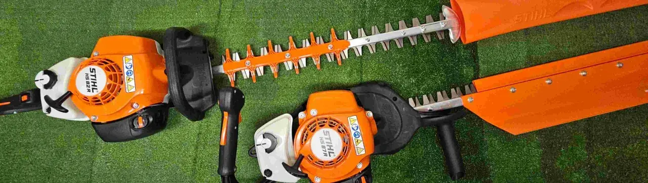 Deux taille-haies Stihl orange et noirs, prêts pour le taillage de haie.