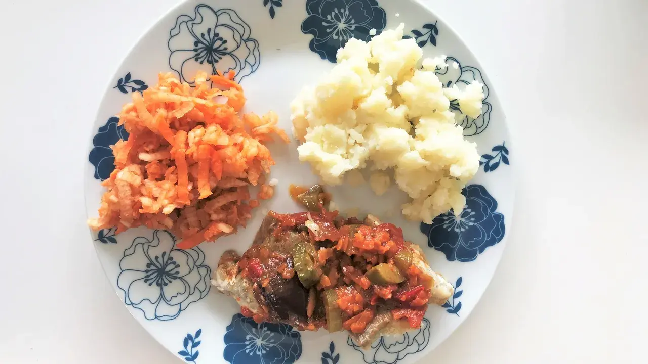 Delikatny posiłek po kolonoskopii: ryba w sosie warzywnym, puree ziemniaczane i surówka z marchewki.