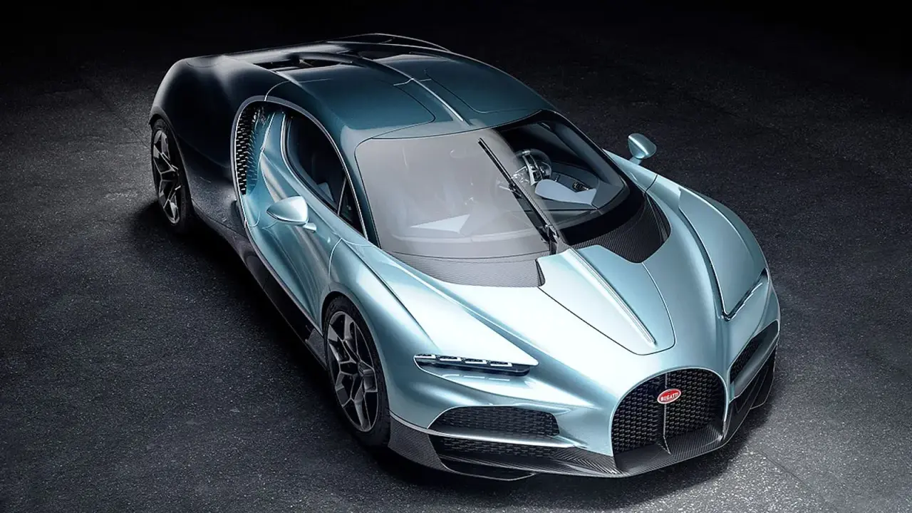 Ein neuer Bugatti in schimmerndem Blau steht auf dunklem Untergrund. Sein Design ist aerodynamisch und luxuriös.