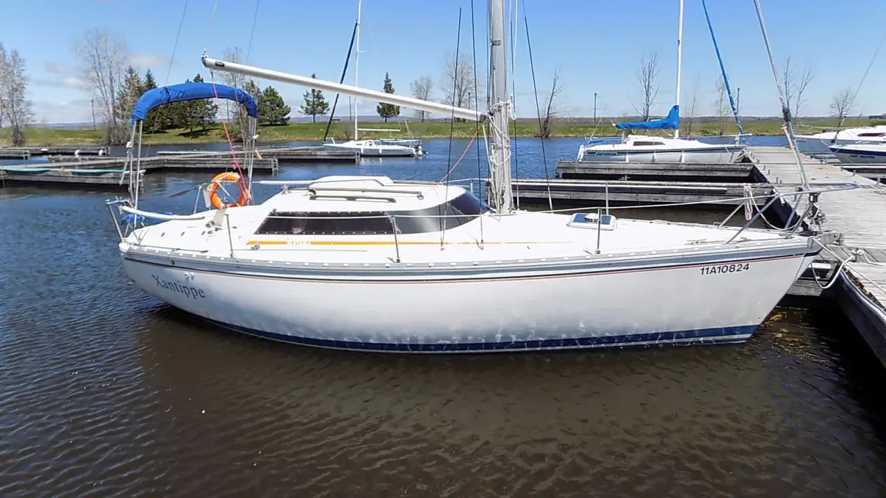 Un voilier blanc, le "Xantippe", est amarré dans un port. Ce bateau de fantasia attend de prendre le large.