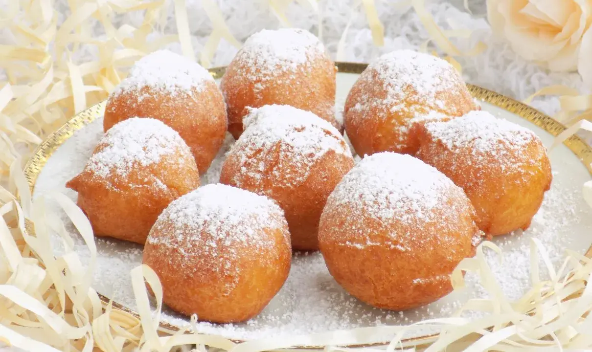 Puszyste paczki z serka homo, posypane cukrem pudrem, kuszą swoim wyglądem. Idealne na deser lub słodką przekąskę.