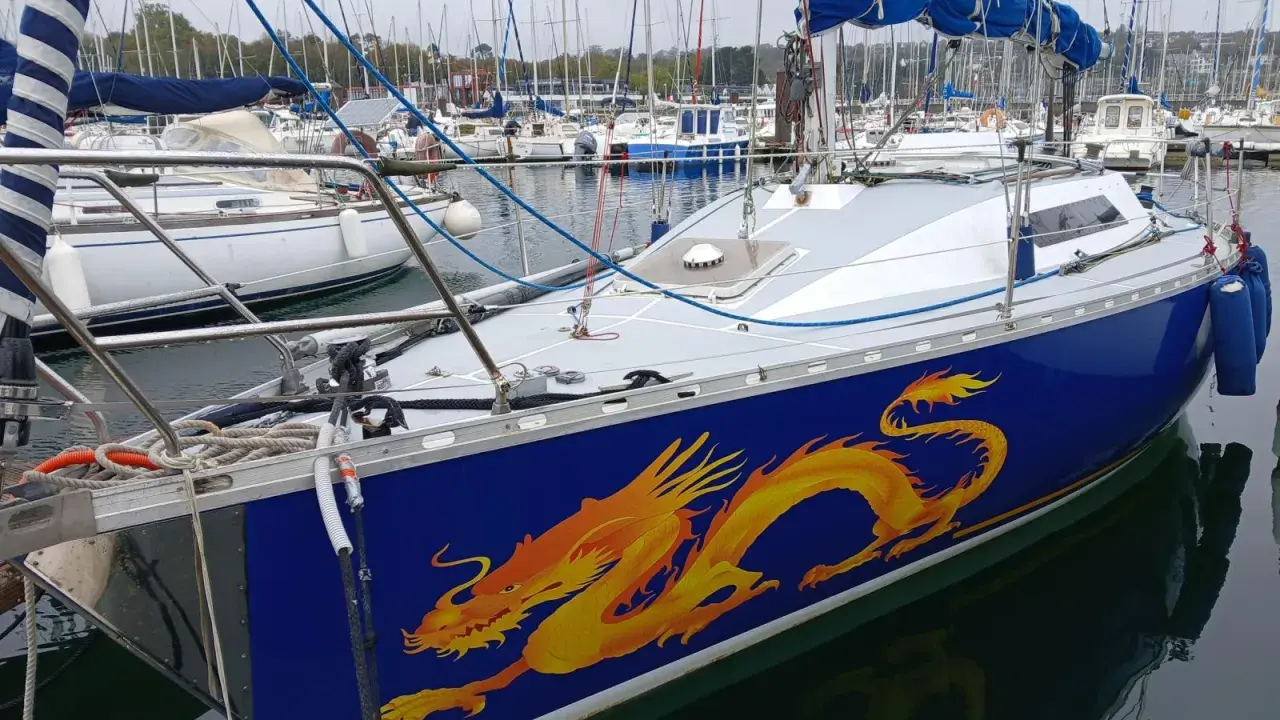 Voilier bleu orné d'un dragon jaune vif, prêt à naviguer. Les premiers 32 avis sont positifs.