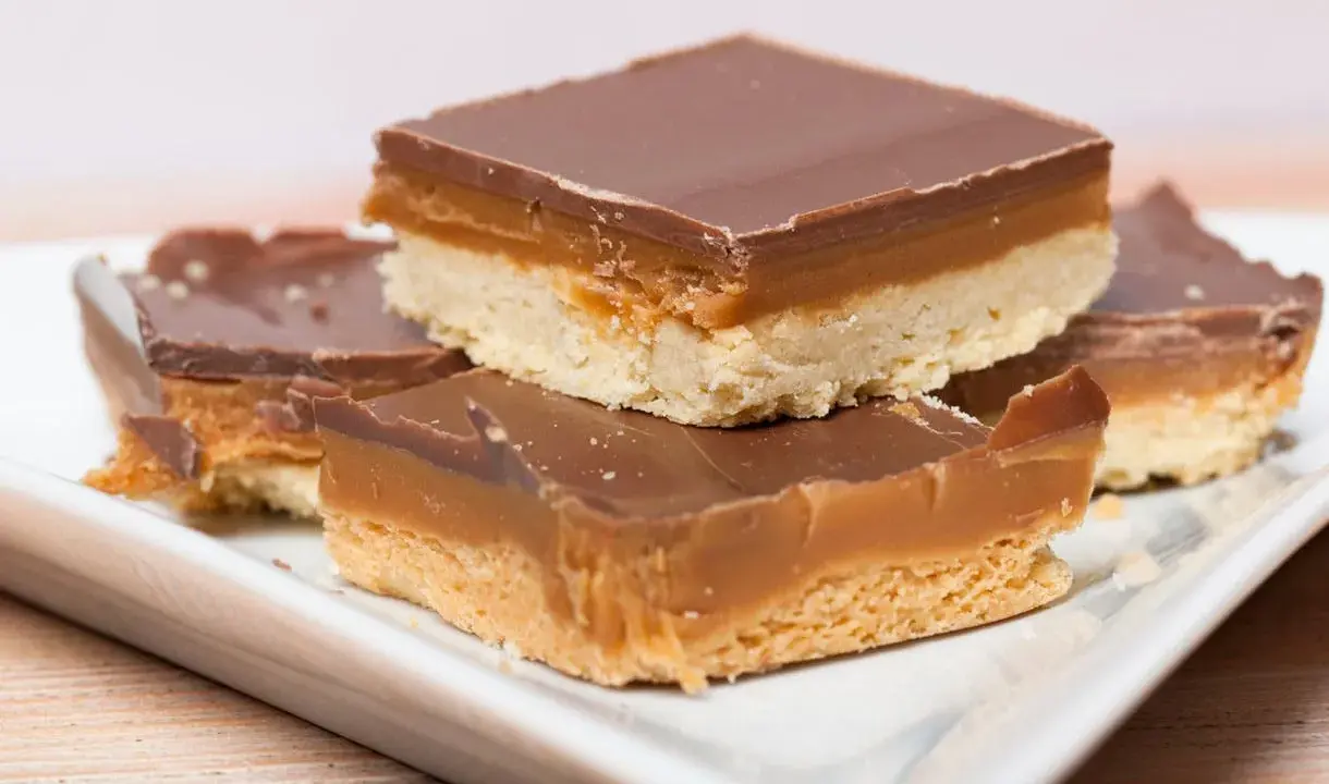 Carrés de shortbread millionnaire au caramel beurre salé, recouverts de chocolat noir. Un délice gourmand.