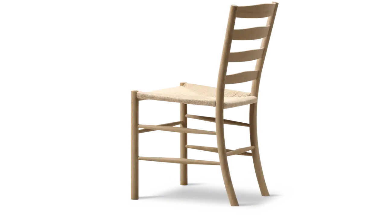 En hög, ljus trästol med flätad sits, inspirerad av Kaare Klints tidlösa design.