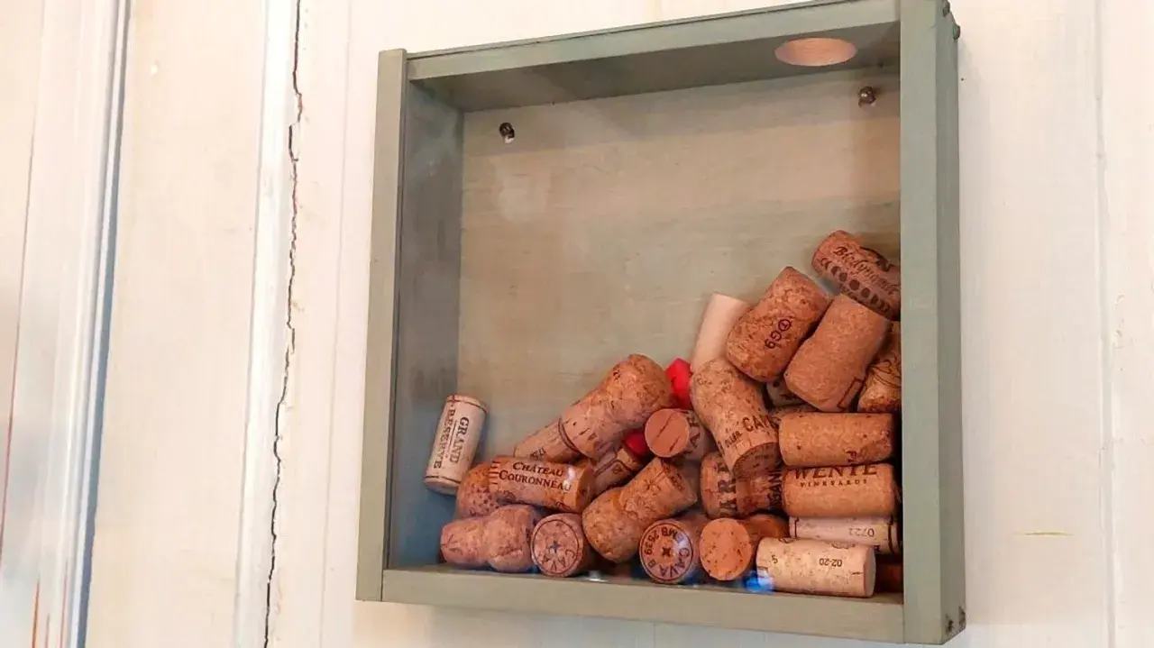 En grå ram fylld med en samling vinkorkar, en tavla som berättar historier från många goda stunder.