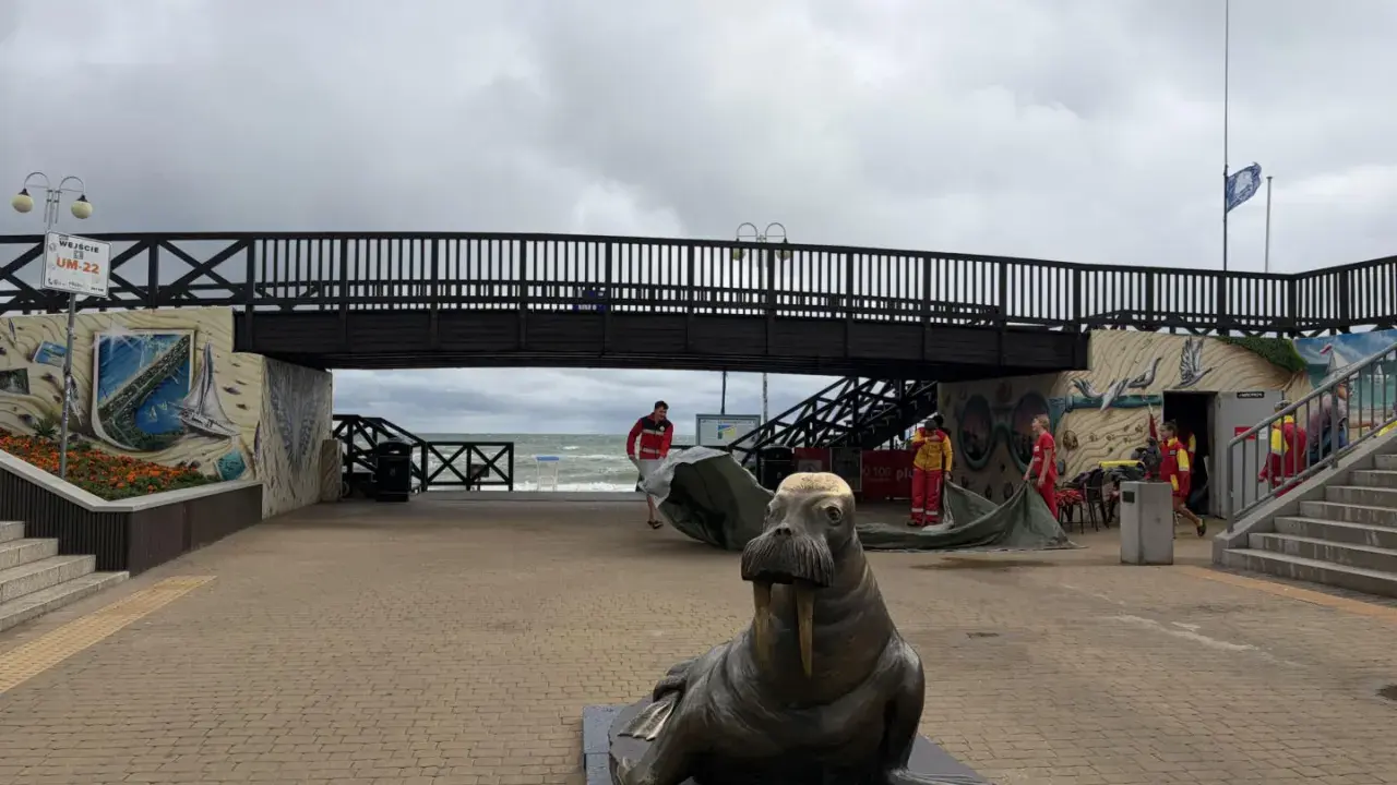 Pomnik foki i most nad plażą w Mielnie. Atrakcje dla turystów, ratownicy przygotowują sprzęt.