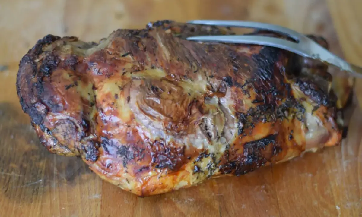 Tranche de gigot d'agneau au barbecue, dorée et savoureuse, prête à être dégustée. Le temps de cuisson parfait pour un plat réussi.