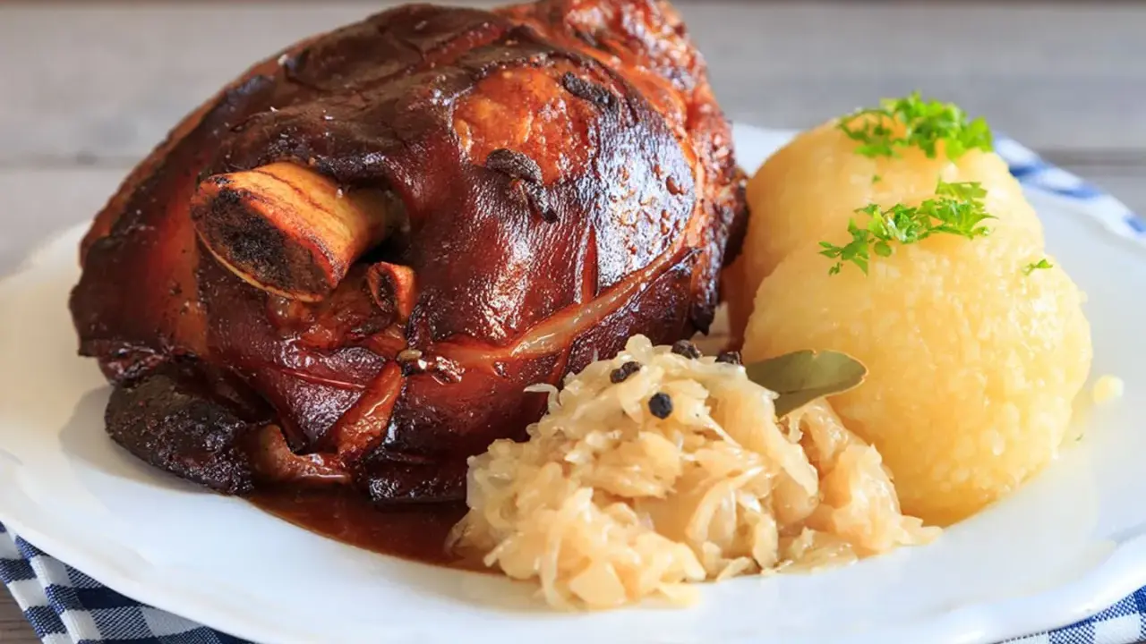 Knusprige Schweinshaxe mit Klößen und Sauerkraut. Ein köstliches Schweinshaxe Rezept für Genießer.