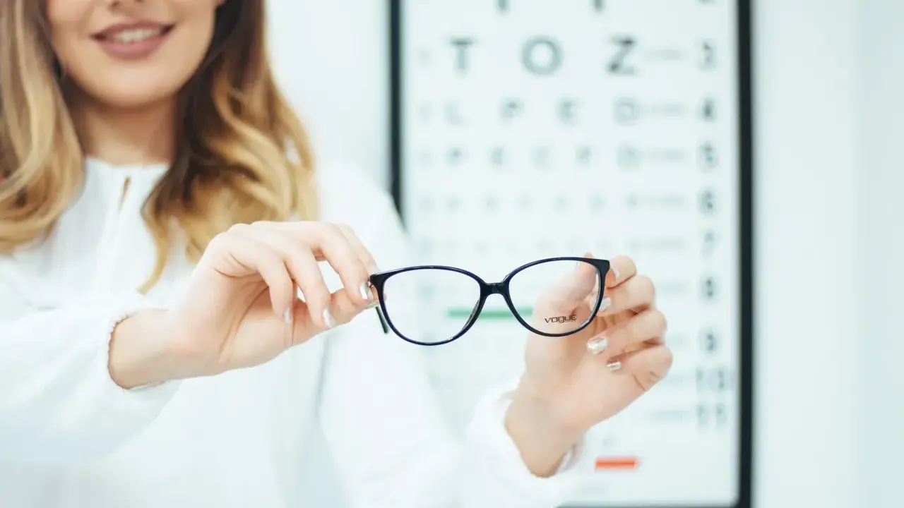 Okulista prezentuje okulary podczas badania wzroku.