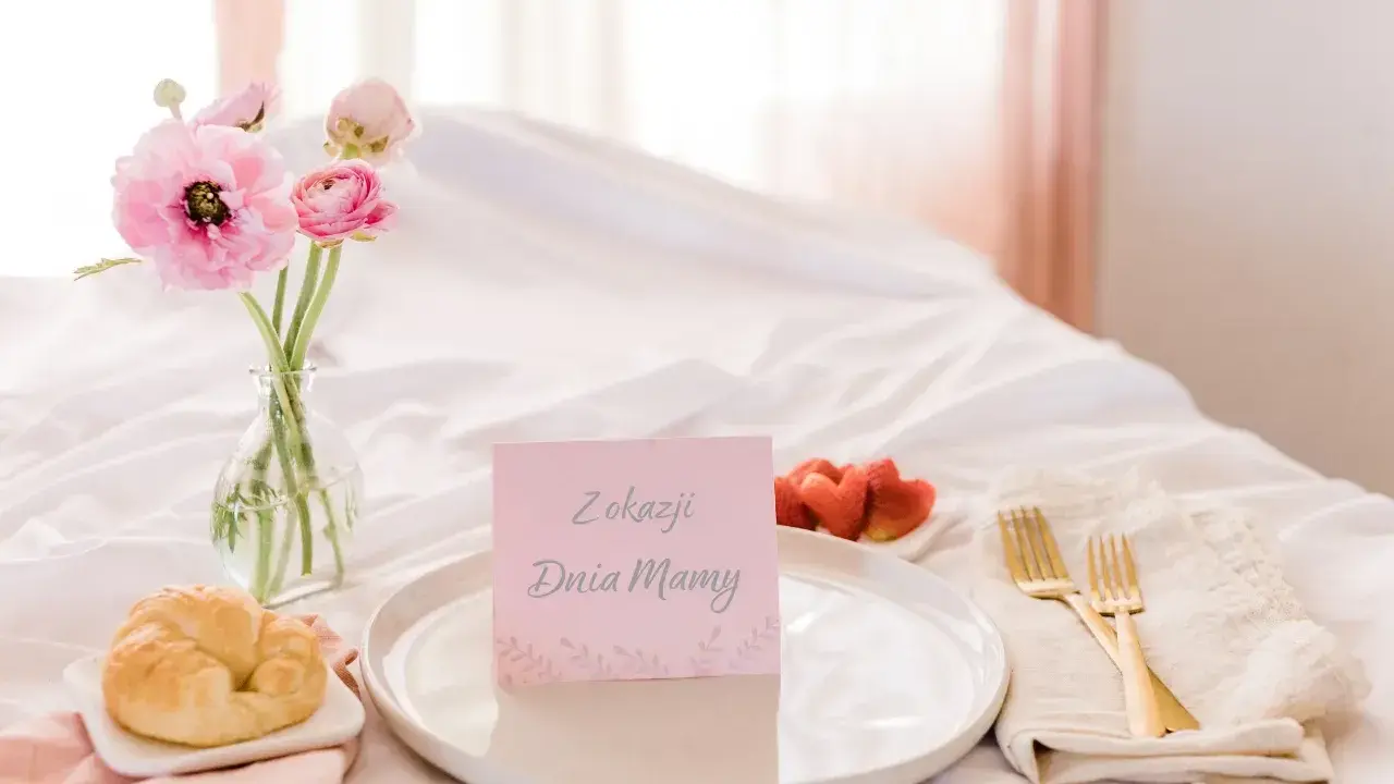 Śniadanie do łóżka dla mamy: rogalik, truskawki, kwiaty i kartka "Z okazji Dnia Mamy". Idealny pomysł, jak zrobić prezent dla mamy na święta.