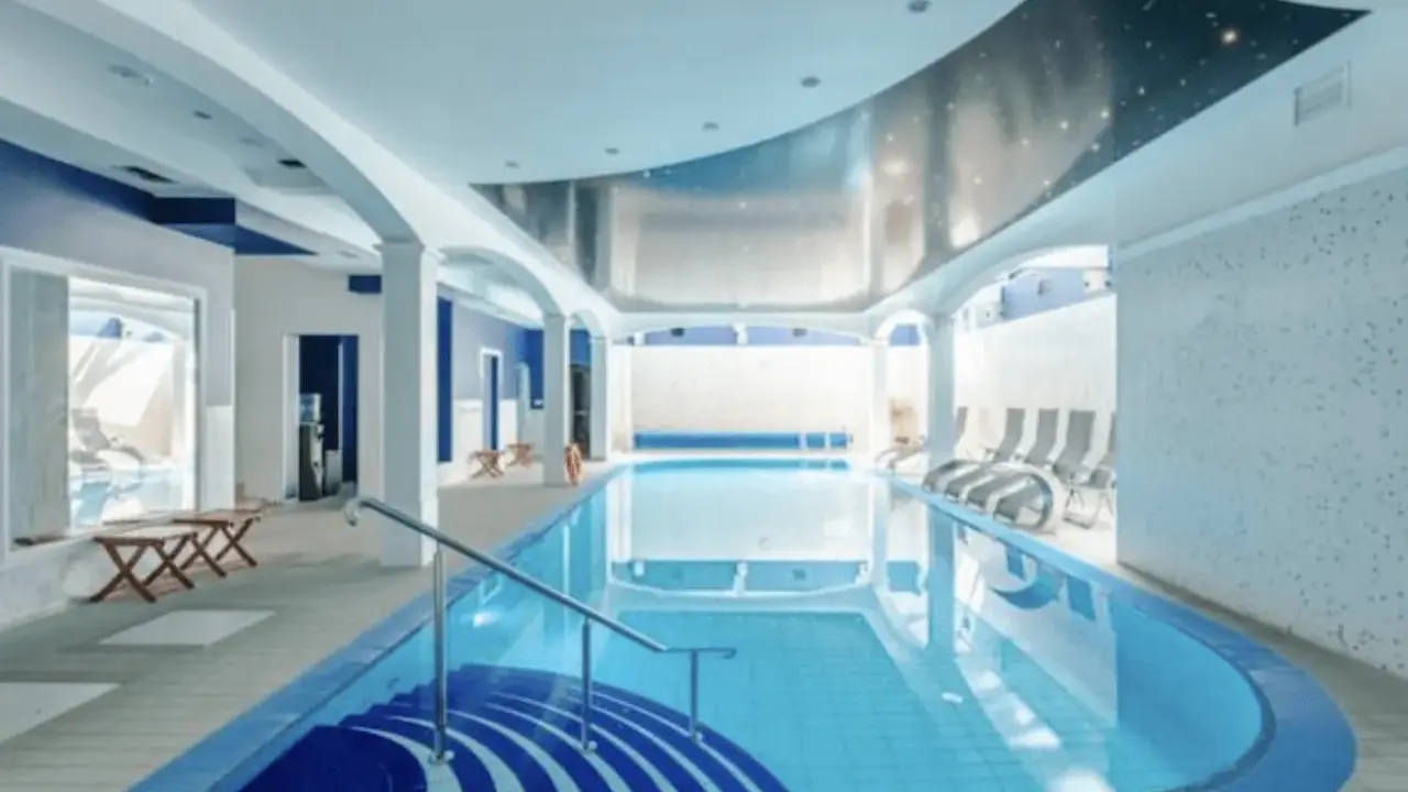 Relaks w spa nad morzem z basenem. Woda w basenie lśni, a sufit ozdobiony jest gwiazdami.