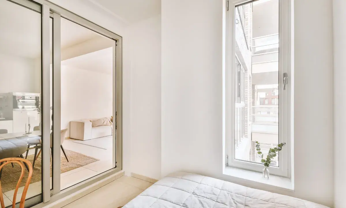 Puerta corredera de cristal que da a un salón. Explora los tipos de cristales para puertas de interior y cómo iluminan tu hogar.