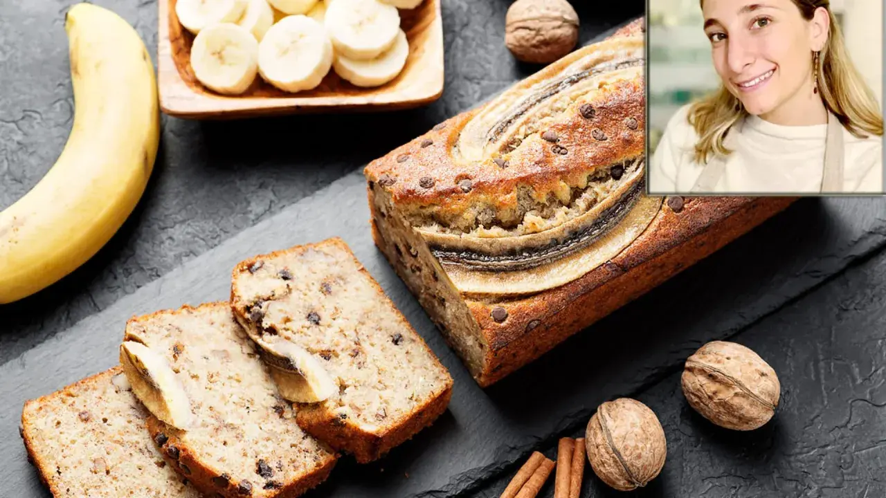 Un delicioso banana bread casero, con trozos de chocolate y plátano en rodajas, junto a nueces y canela.