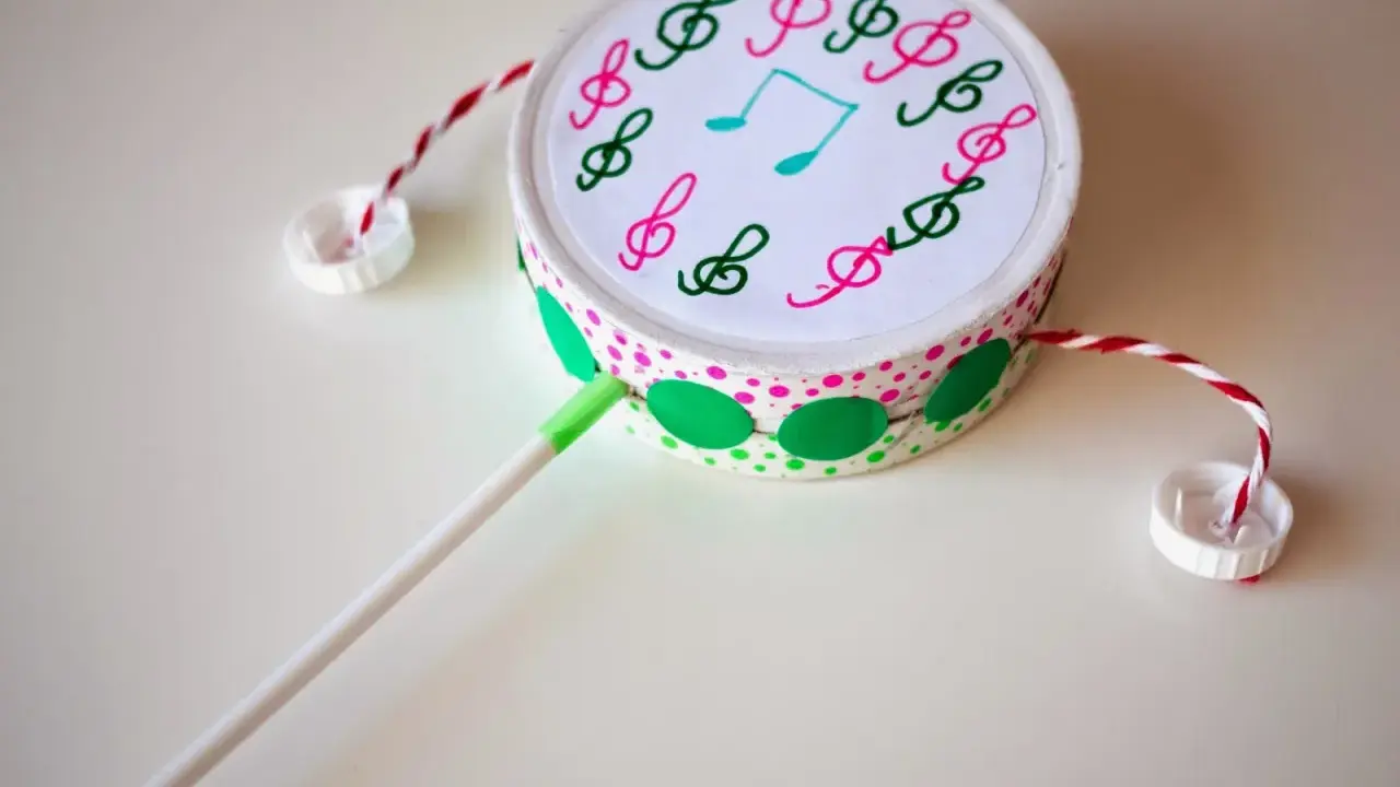 Tambor decorado con notas musicales, hecho con **instrumentos con materiales reciclados**. Ideal para crear música.