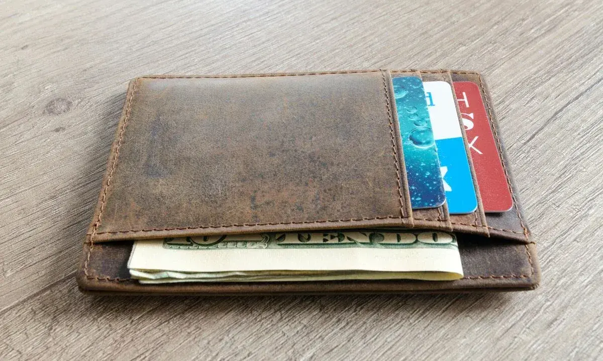 Brązowy, skórzany portfel z kartami i banknotami. Dowiedz się, jak wyczyścić skórzany portfel, by wyglądał jak nowy.