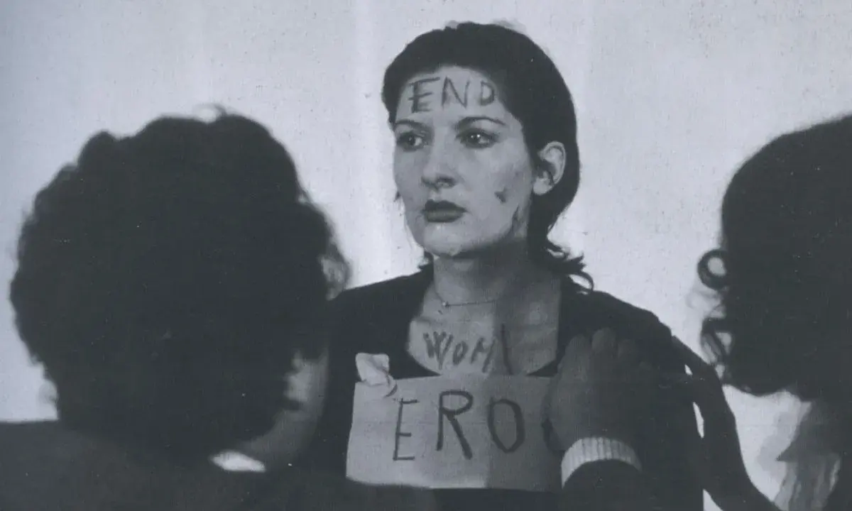 Marina Abramović en "Rhythm 0", con "END" escrito en su frente y "WOMAN ERO" en su pecho.
