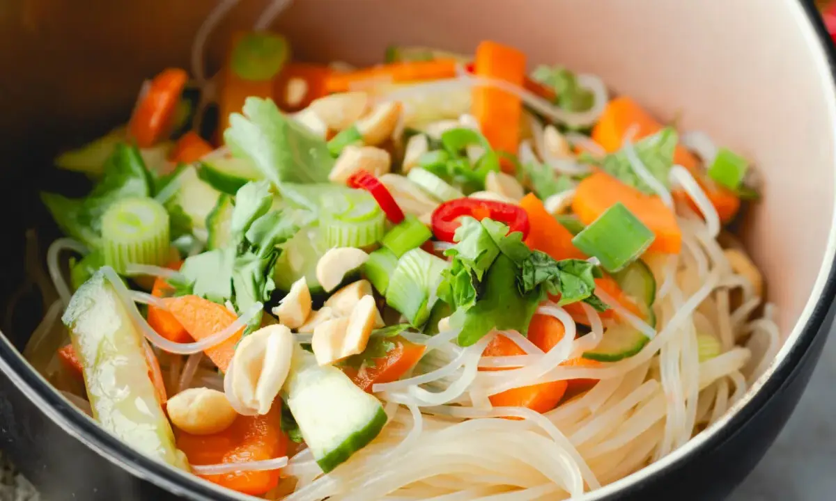 Frischer Glasnudel Salat mit Karotten, Gurken, Frühlingszwiebeln und Erdnüssen in einer Schüssel.
