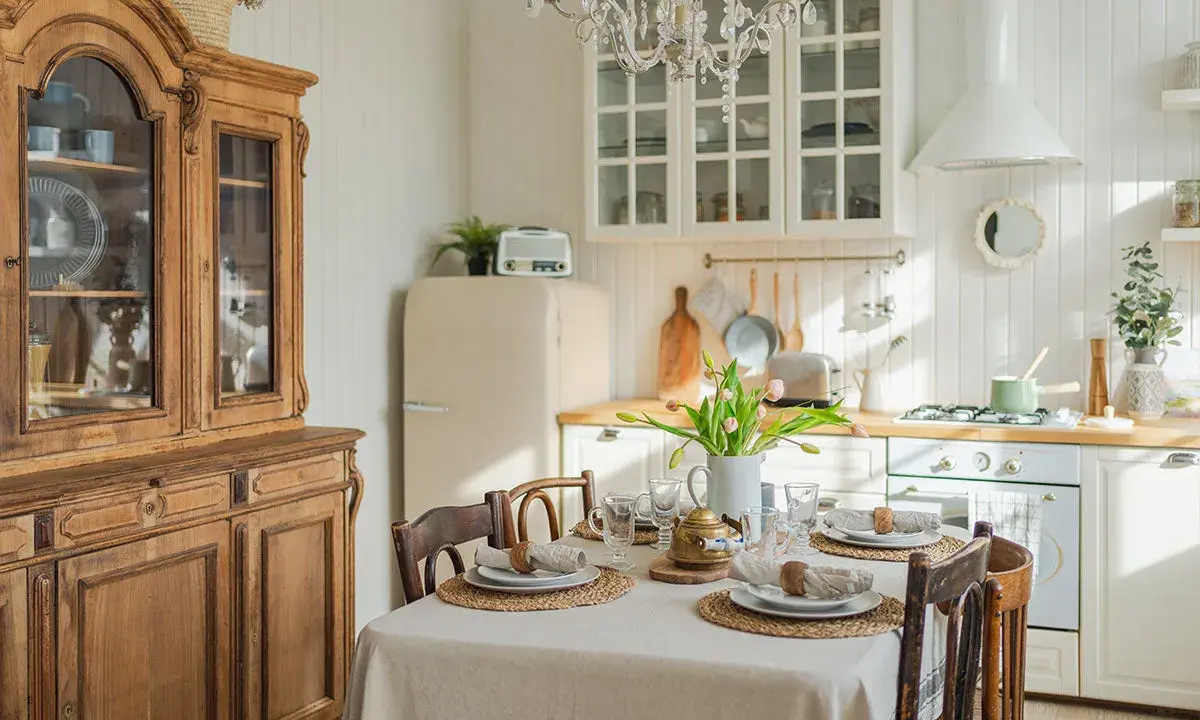 Table dressée pour un repas, avec un buffet ancien et une cuisine lumineuse, évoquant une ambiance de spécialité provençale.