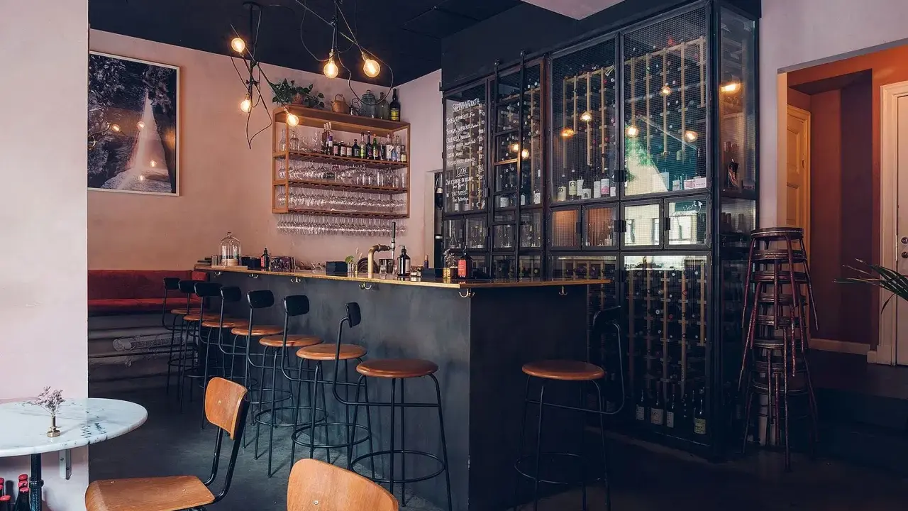 Mysig vinbar i Stockholm med en stor vinkyl, bardisk och sittplatser.